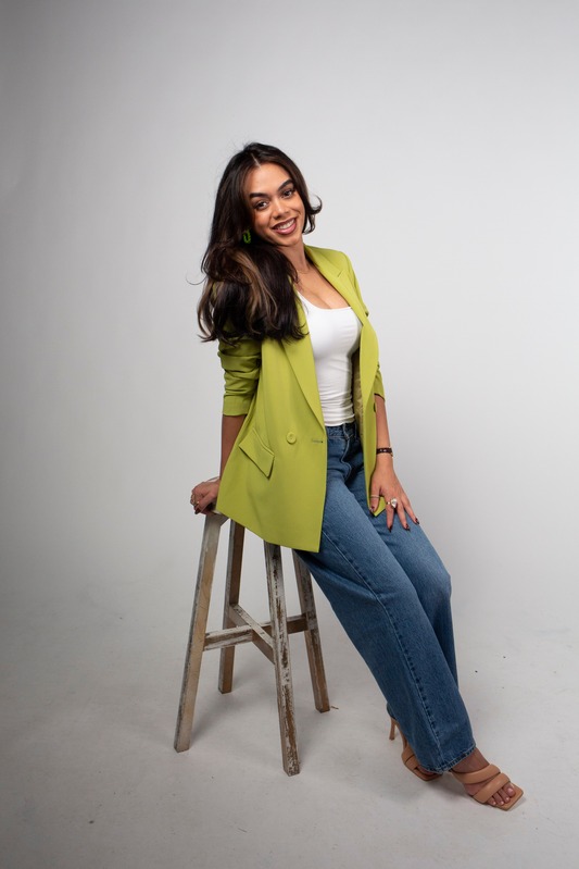 Veronica seated on a stool, smiling